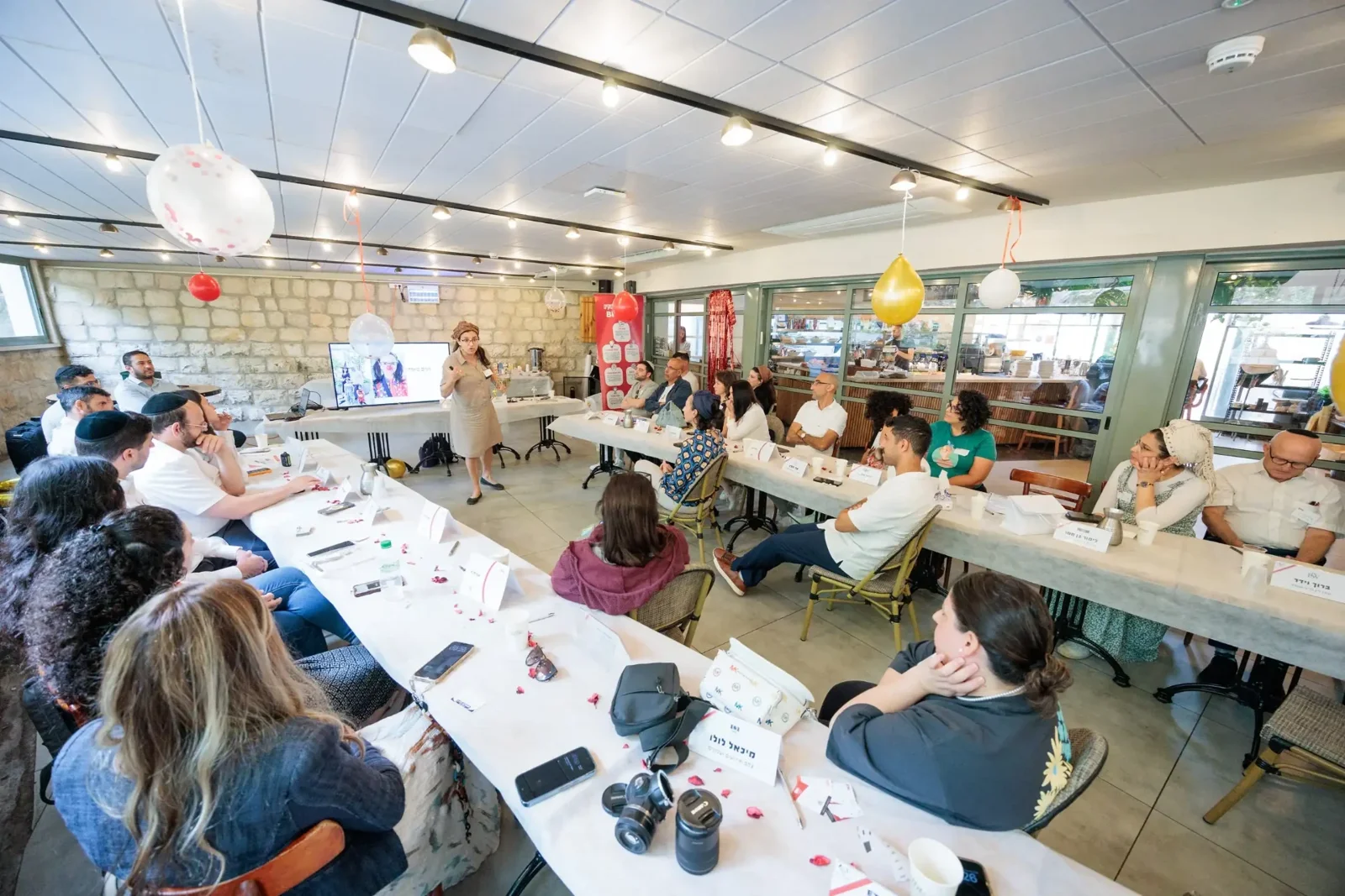 חברי קבוצת הבירה משתתפים במפגש השבועי סביב השולחנות